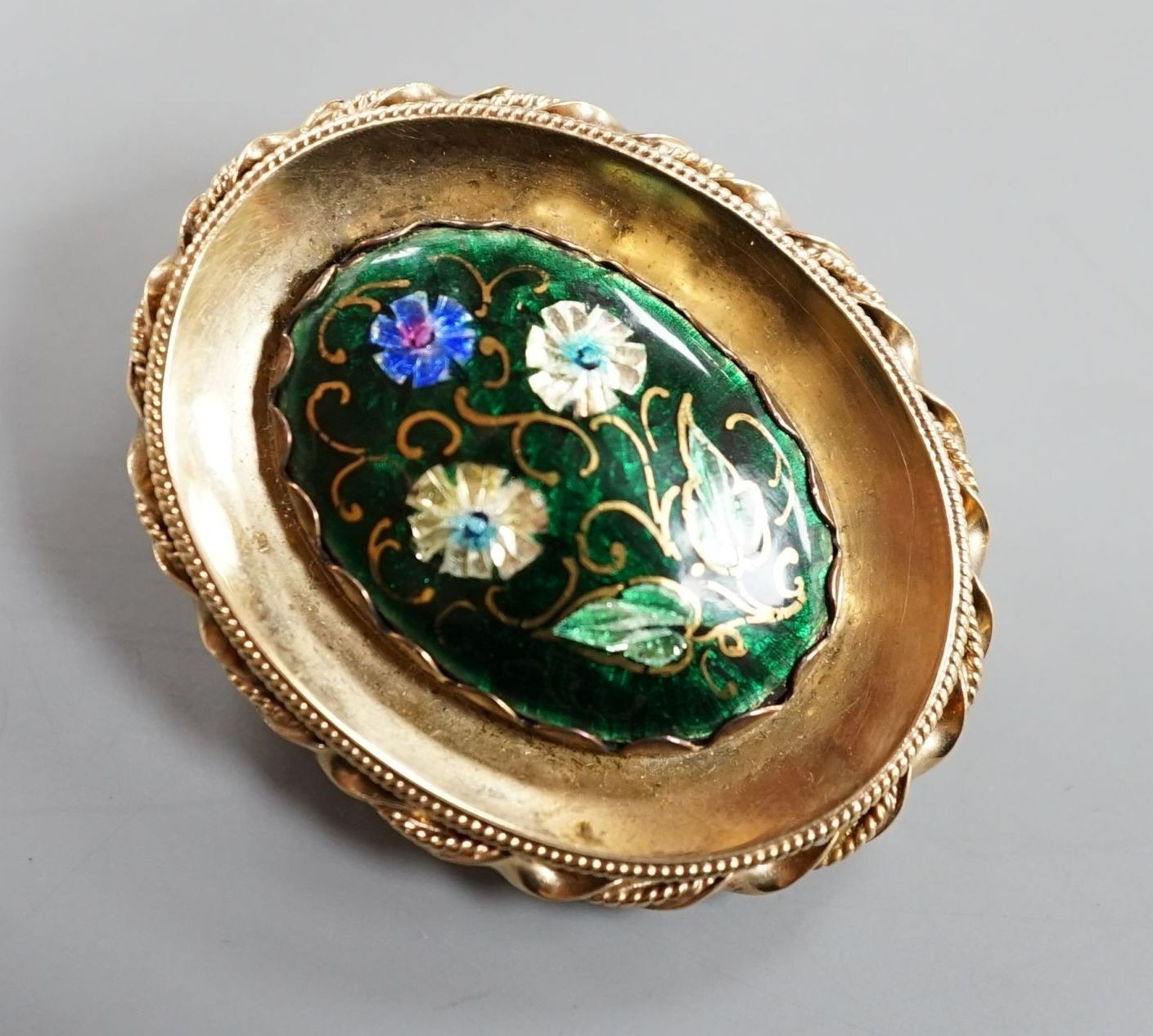 A 1960's 9ct gold and polychrome enamel set oval pendant locket, 42mm, gross 14 grams.